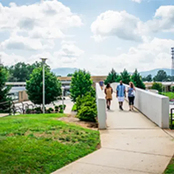 Three students waling across A-B Tech's cross walk bridge