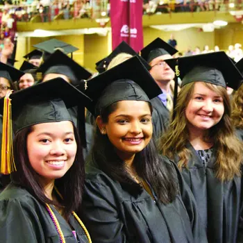 Three students in graduation caps and gowns