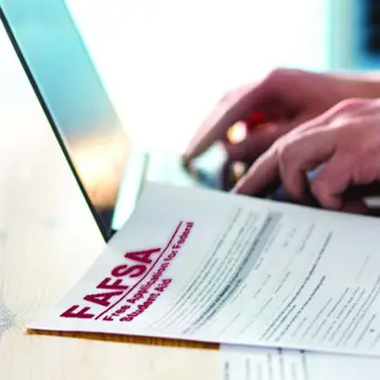 Someone's hands typing on a laptop with a FASA application in the fore-ground.
