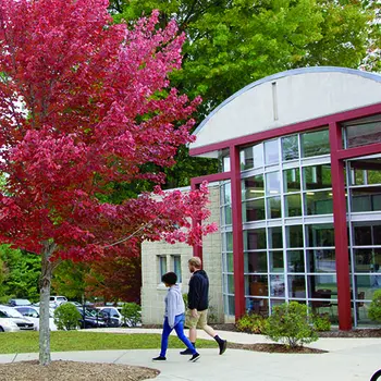 Two students walking in front of Student Services/Bailey Building in the Fall.