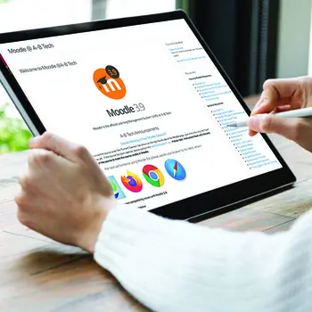 Person working on a tablet with a Moodle page open.