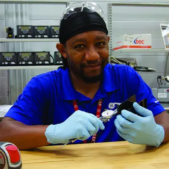 Student measuring a part with calipers