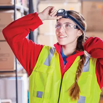 Student wearing a safety vest, safety glasses and a headlamp light