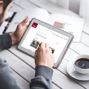 Male holding an iPad with A-B Tech's site on the screen.
