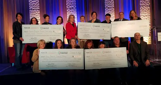 Winners posing with checks.