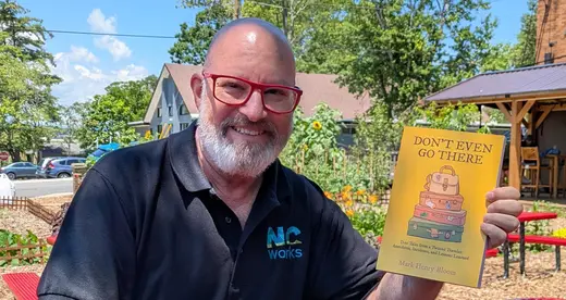 Mark Bloom holding his book