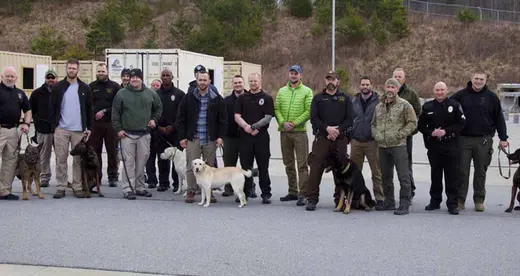 Handlers and their dogs standing outside