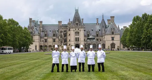 six chefs standing on a lawn in front of the Biltmore House