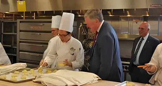 Mark Meadows at counter talking to a  Baking and Pastry Arts student