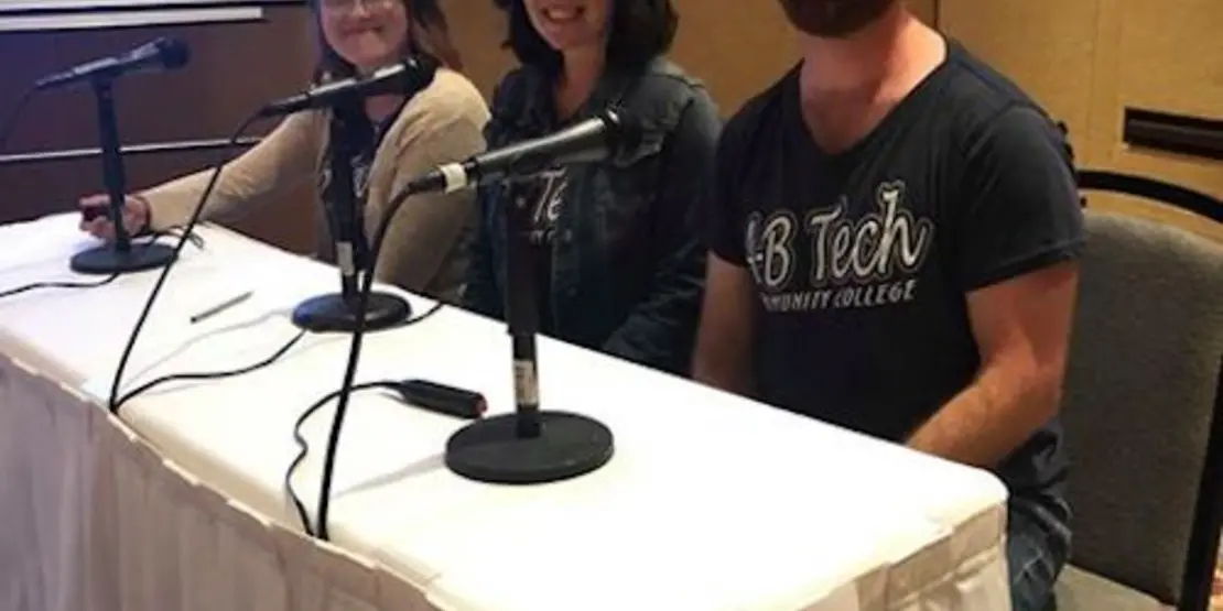 Ashley Gillett, Vincent Gendusa and Amy Taylor sitting at a Quiz Bowl table