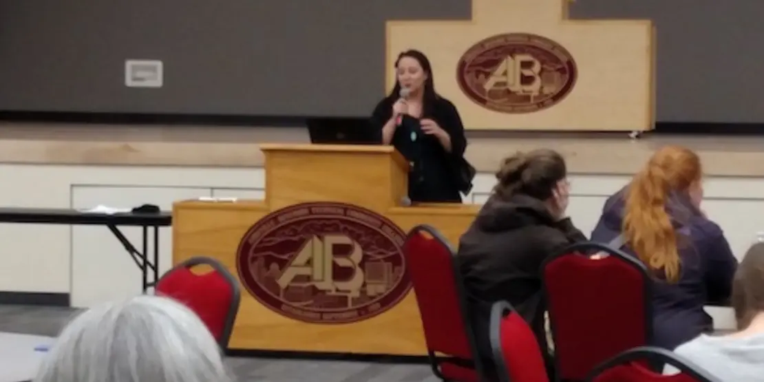 Ariel Rhymer speaking behind podium 