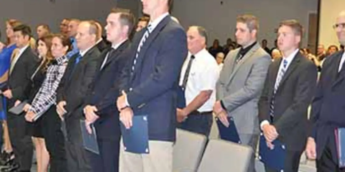 Three rows of BLET graduates in auditorium seats.