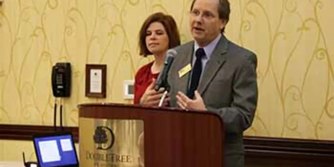 Dave White at a lectern with Heather Pack.