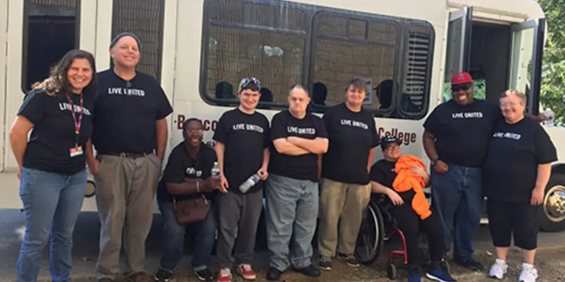 People standing in front of a bus at United Ways Days of Impact event