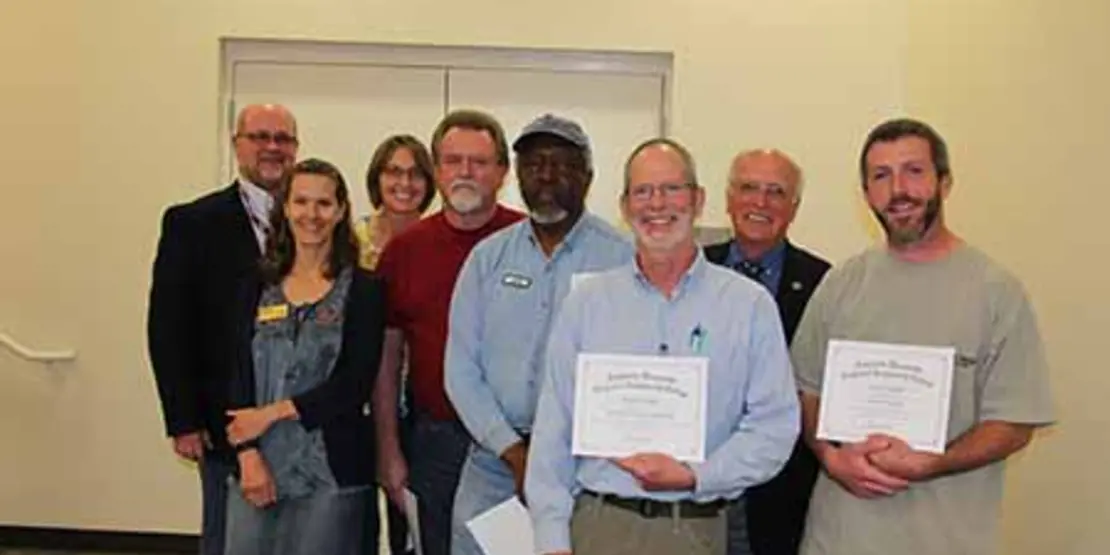 Eight people standing with certificates