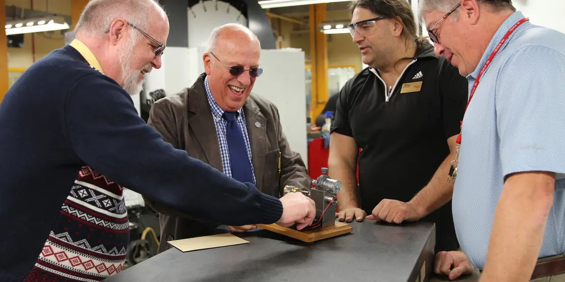 Four men and a miniature engine lathe