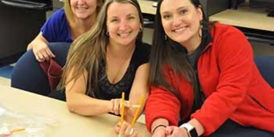 Three women with their winning catapult design.