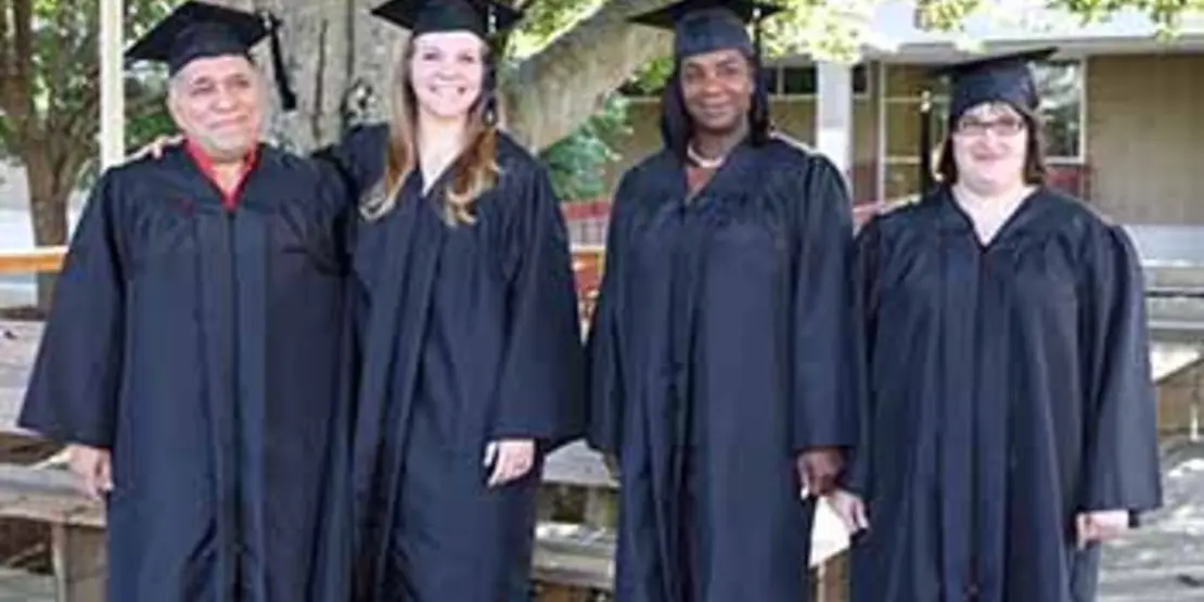 Four graduates standing on a deck