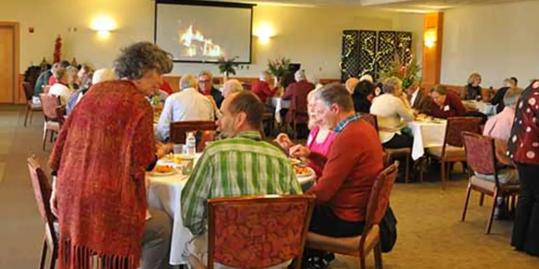 Men and women in a dining room eating brunch. 
