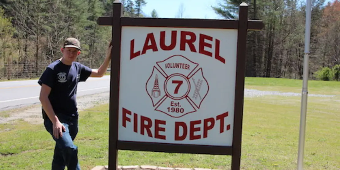 Scott Hensley standing next to the Laurel Fire Dept. sign.
