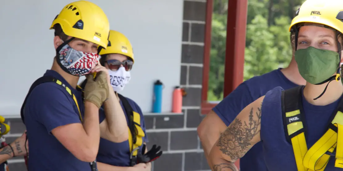 Three students in rappelling gear