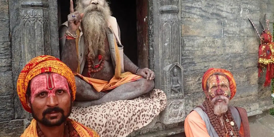 Three men sitting in front of a building in Nepal