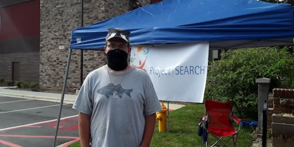 Noah Britton next to a tent