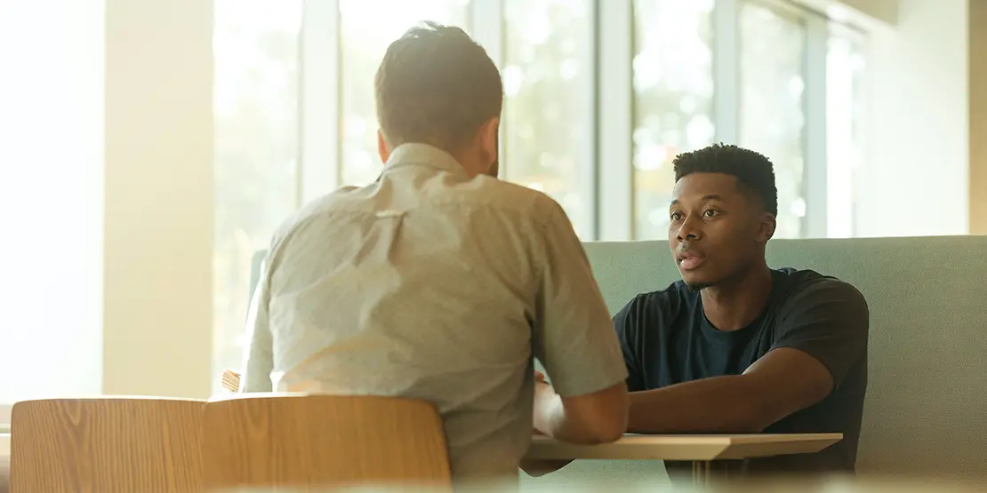 Two men sitting at a table talking