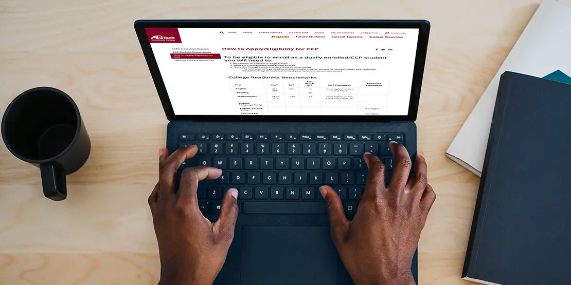Image of two hands typing on a laptop