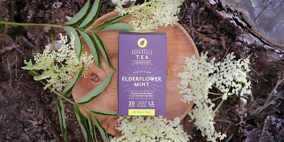 Box of tea sitting beside white flowers