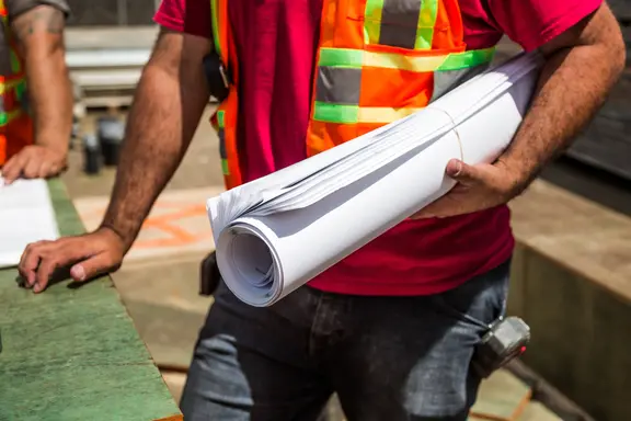 construction worker holding plans on jobsite