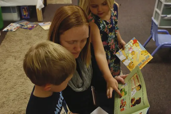 Woman reading to two children