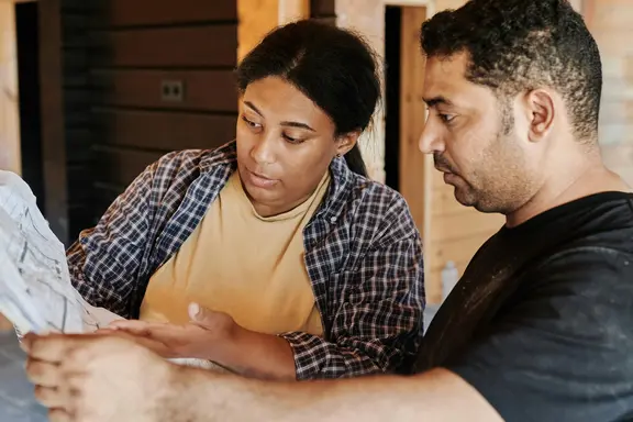 Latinx workers looking at blueprint - residential design image