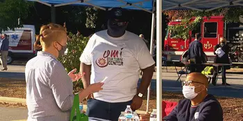 Two men behind a table talking to a client
