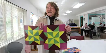 Marilyn Hoffman holding a quilt
