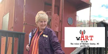 Woman standing in front of a train caboose